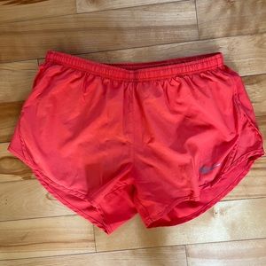 Bright orange Nike running shorts. Size medium.